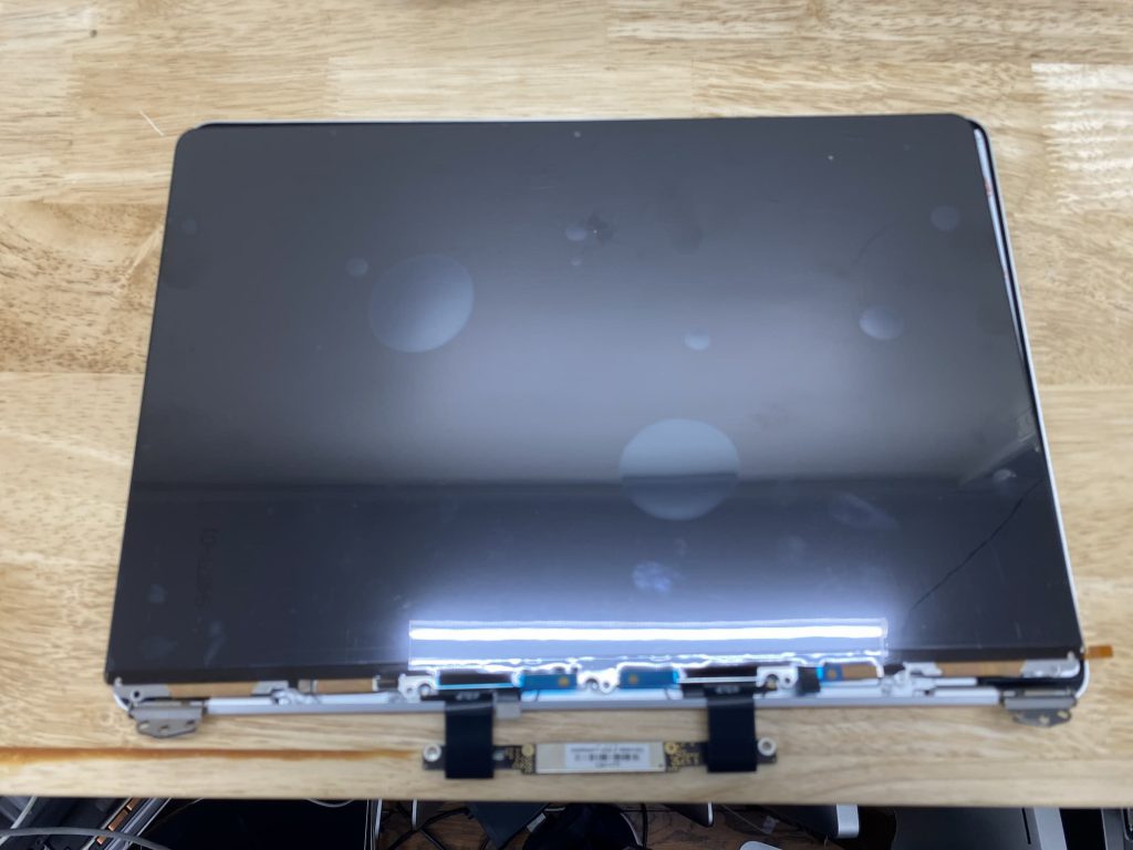 New LCD panel being installed in MacBook Air housing.